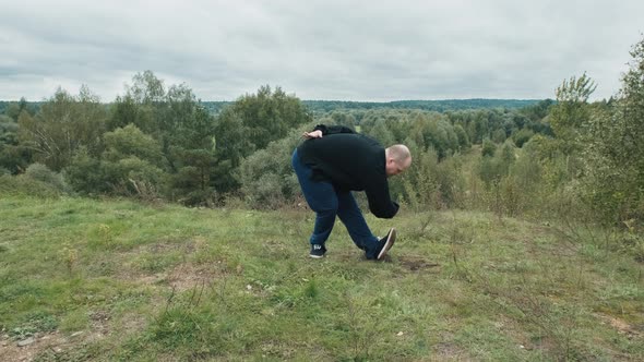 Caucasian Man is Engaged Traditional Chinese Gymnastics Qigong and Tai Chi