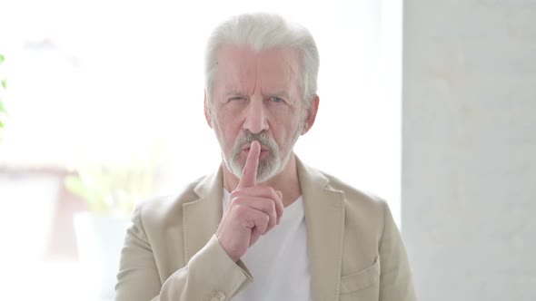 Old Man Showing Quiet Sign By Finger on Lips