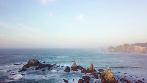 drone flies over the rocks in the ocean