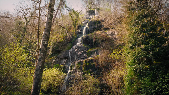 Waterfall Cascading Down Rock Face In The Woods