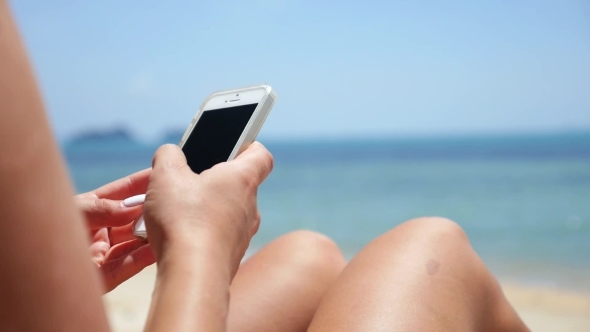 Woman Using Mobile Phone On Beach - Travel And