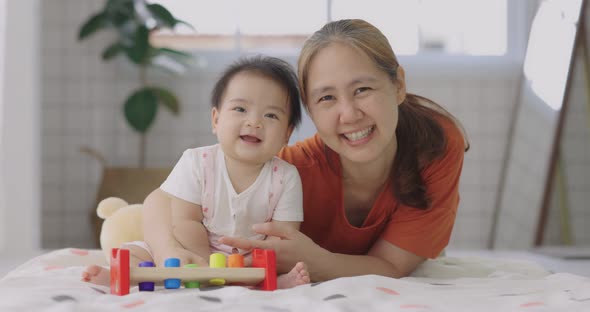 Happy Asian Mother Playing With Cute Small Daughter.