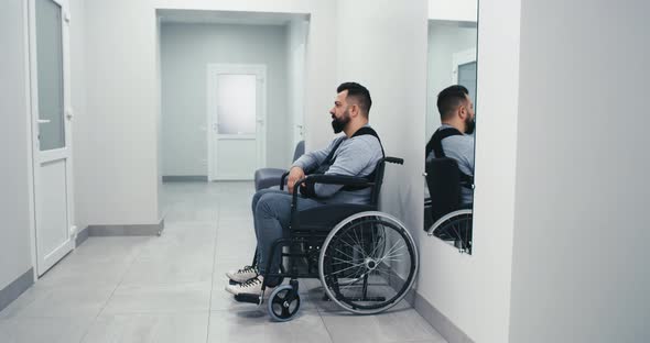 Man with Disability Waiting in Clinic Corridor