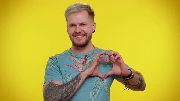 Smiling Tourist Man Makes Heart Gesture Demonstrates Love Sign Expresses Good Feelings and Sympathy