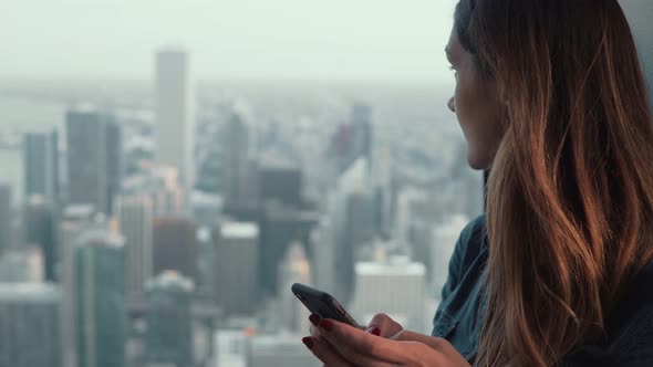 Portrait of Young Attractive Woman Standing Near the Window in Skyscraper in Chicago, USA 