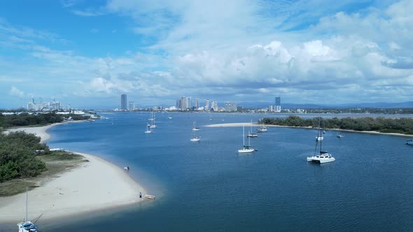 Aerial view of a safe boat harbor on a clear blue sky day with a city skyline in the distance