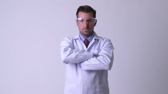 Young Hispanic Man Doctor Wearing Protective Glasses with Arms Crossed