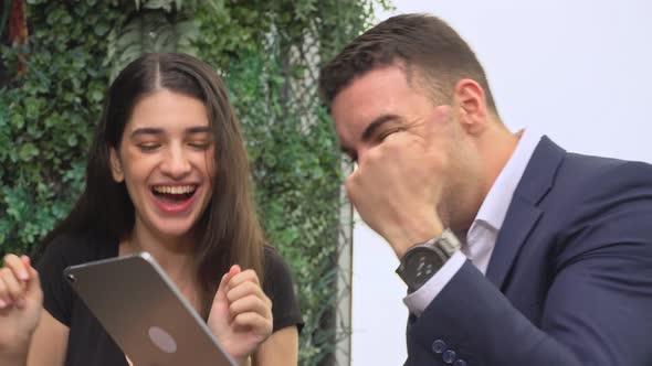 Man and woman excited receiving good news and fist bump together