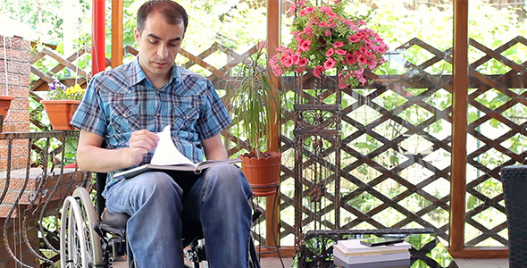 Young Disabled Man Reading Book