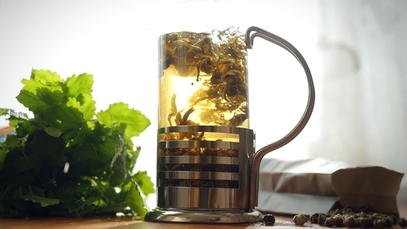 Slowmotion Of Glass Teapot With Blooming Tea