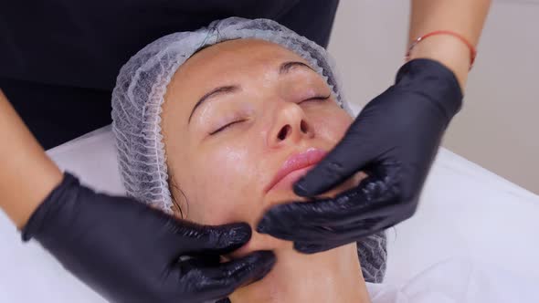 Close-up, Cosmetologist, in Black Medical Gloves, Performs Skincare Procedure, Facial Massage 