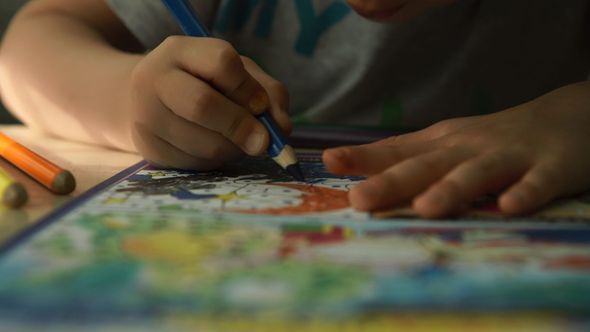 Child Hands Draws a Green Pencils on a Paper