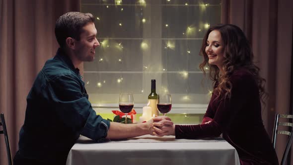A Man Takes the Hand of His Beloved Woman During Dinner