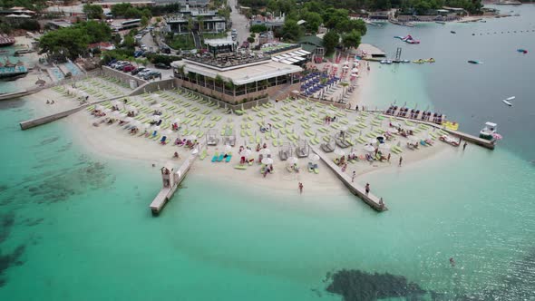 Aerial Azure Beach with Empty Sun Loungers and Boats Balkan Sea Coast Albania