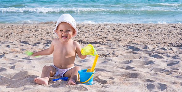 Child Plays on the Sea Beach in the Sand