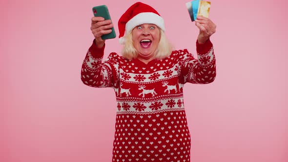 Senior Christmas Grandmother Woman Use Mobile Cell Phone Plastic Credit Bank Cards Win Calebrate Wow