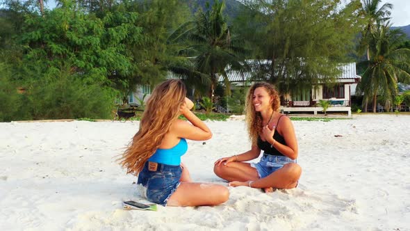 Ladies together happy together on tranquil shore beach lifestyle by transparent lagoon and clean san