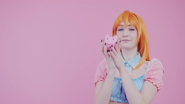 Joyous European Woman 20s Holding Piggybank with Lots of Money Isolated Pink Background Studio Shot