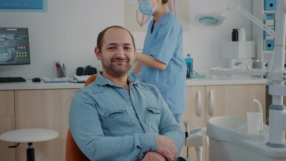 Portrait of Patient Sitting in Dental Chair at Oral Care Clinic