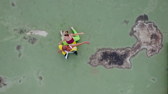 Drone Shot Of Models In Green And Yellow Dancing On City Rooftop