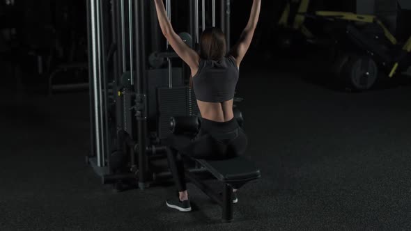 Female in the Gym Lifting Blocks on Rack Machine Back View Training on Block Device and Gym