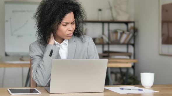 Tired African Businesswoman with Neck Pain Working on Laptop