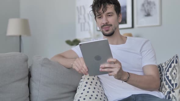 Online Video Chat on Tablet By Casual Young Man at Home