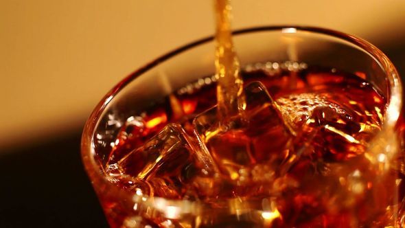 Whiskey Pours Into A Glass With Ice Cubes