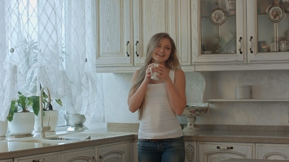 Beautiful Girl Drinks Tea On Kitchen At Morning