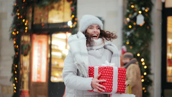 A Woman is Standing in the City Center During a Snowfall