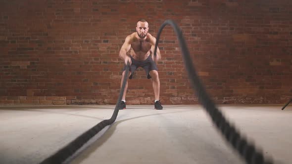 Man Is Doing Battle Rope Exercise While Working Out at Cross-fit Training