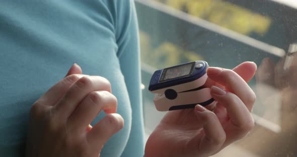 Close Up Of Female Hands Using Pulse Oximeter Checking Oxygen Level