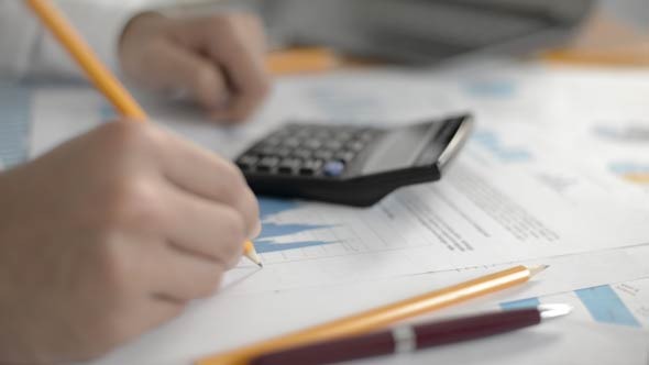 Businessman Calculating Data on Calculator