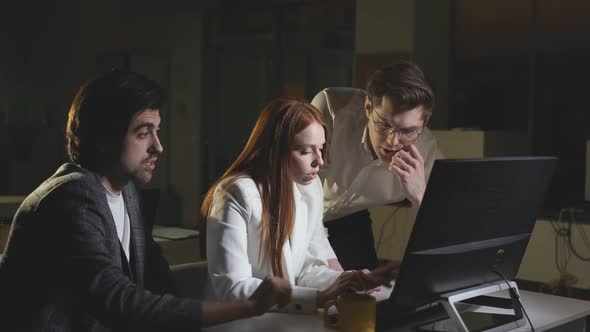 A Group of Young Business Colleagues is Working on a Project at Night in the Office