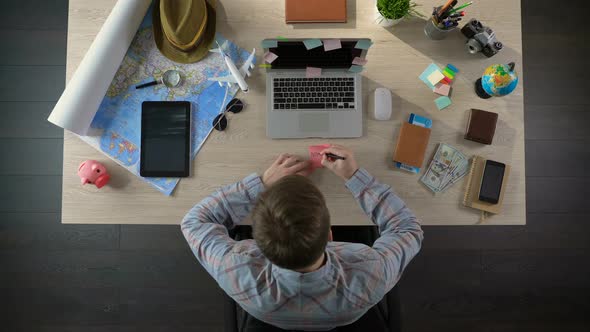 Man Writing New York on Sticky Paper, Choosing City for Trip, Travel Destination