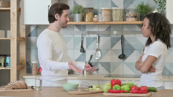 Young African Woman Arguing with Young Man in Kitchen