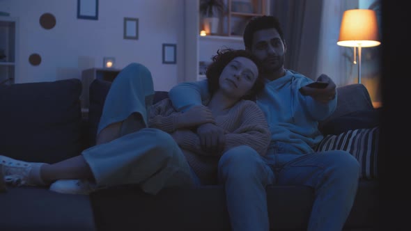 Couple Turning on TV in Evening