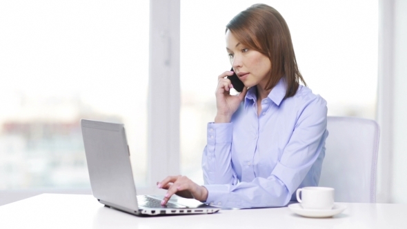 Businesswoman With Laptop And Smartphone At Office