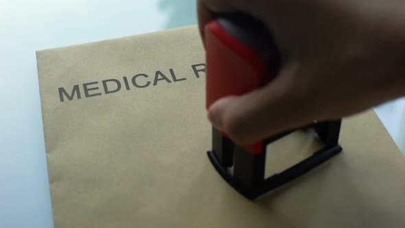 Medical Records Private, Hand Stamping Seal on Folder With Important Documents