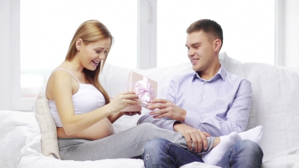 Happy Husband Giving Present To His Pregnant Wife
