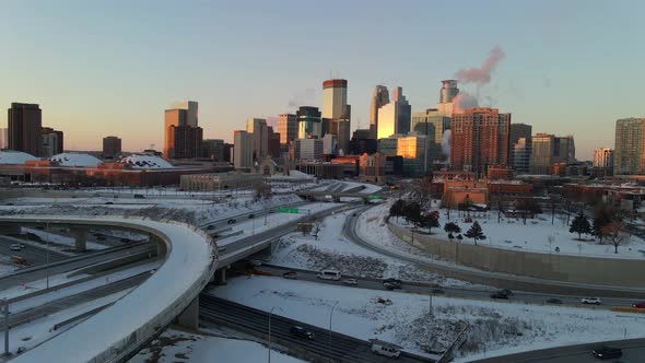 Aerial footage of Minneapolis downtown skyline and main highways during a winter golden hour