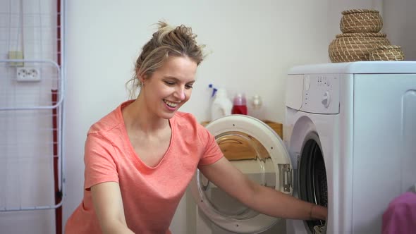 Smiling Woman Housewife Load Washer with Dirty Laundry