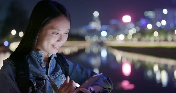 Woman look at the cellphone in city at night