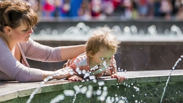 Baby Boy Touching Water In The Fountain