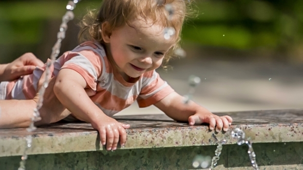 Baby Boy Playing With Water In Fountain