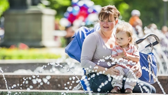 Mother And Baby Enjoying Fountains In The Park