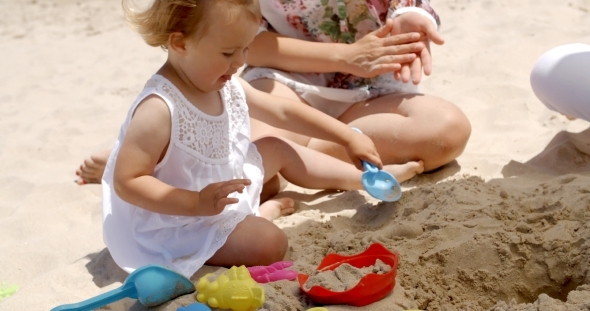 Little Girl Playing With Sand Toys At The Beach