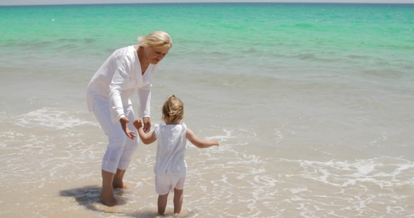 Grandmother And Little Girl Enjoying At The Beach