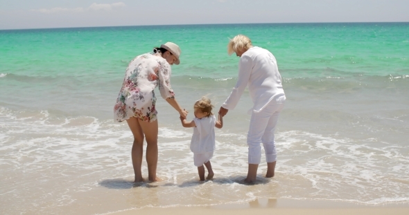 Grandma And Mom Holding Little Girl At The Beach