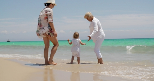Girl Enjoying At The Beach With Mom And Grandma